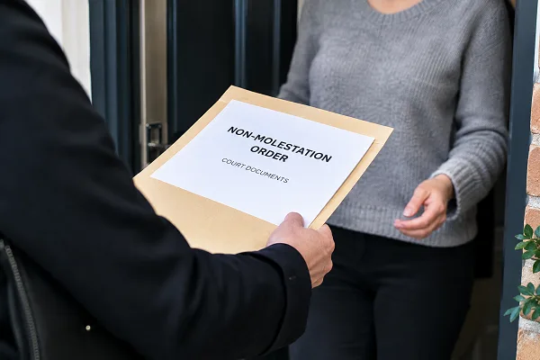 man handing over non molestation order
